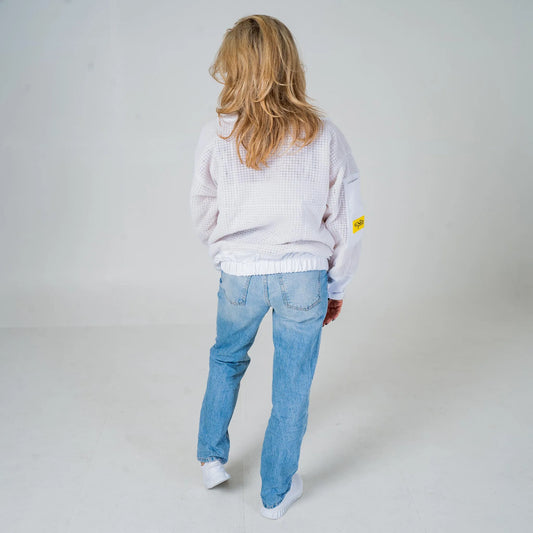 Woman wearing OZ Armour white 3 layer beekeeping jacket with the veil removed, full length back view walking away