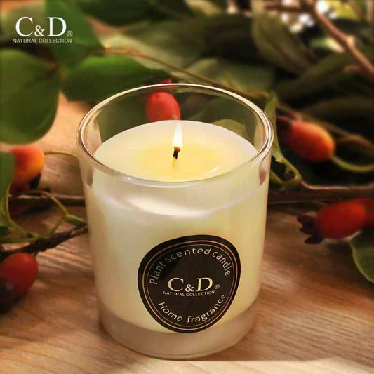 Scented soy candle in glass jar with warm flame