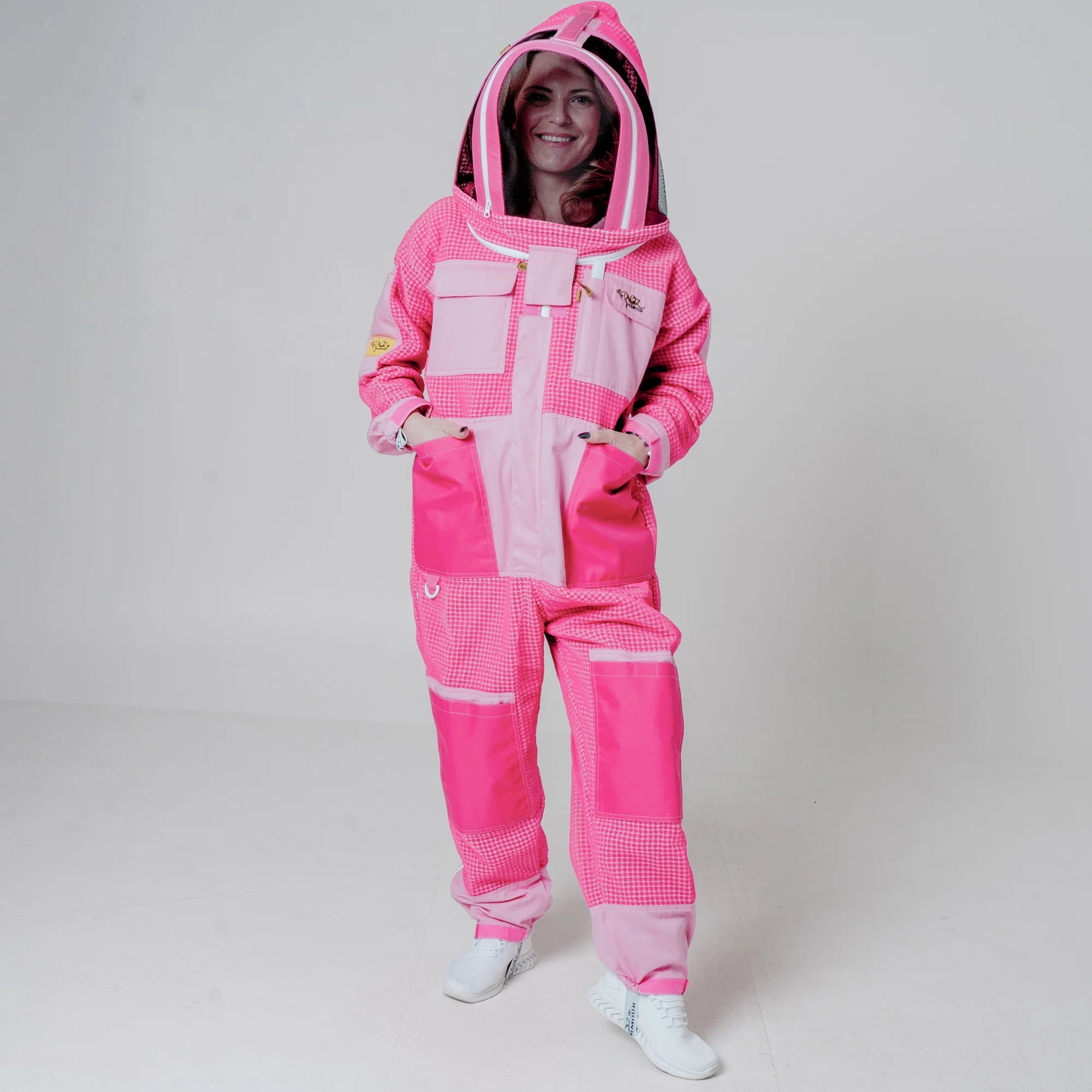 Woman wearing 3 layer mesh pink beekeeping suit with fencing veil, full body front view