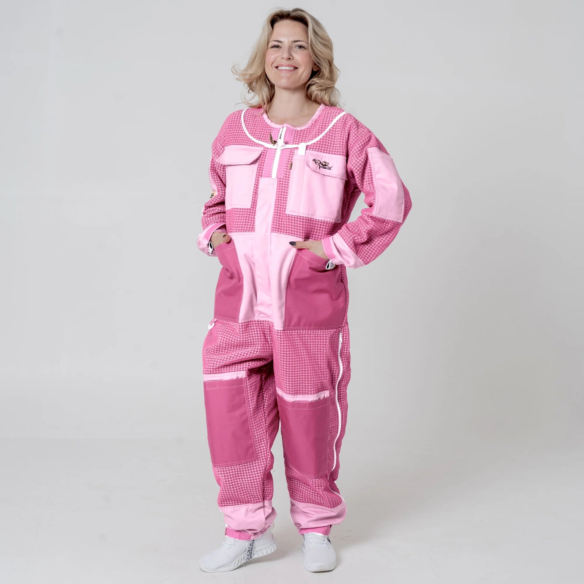Woman wearing 3 layer mesh pink beekeeping suit without veil, front view with hands on pockets