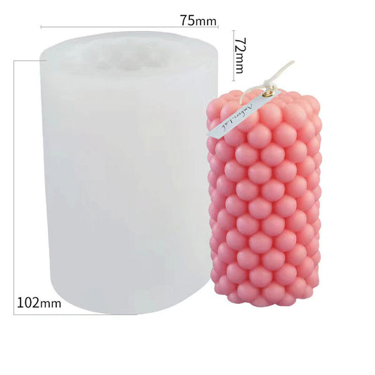 Bubble shape candle mould beside finished pink bubble candle