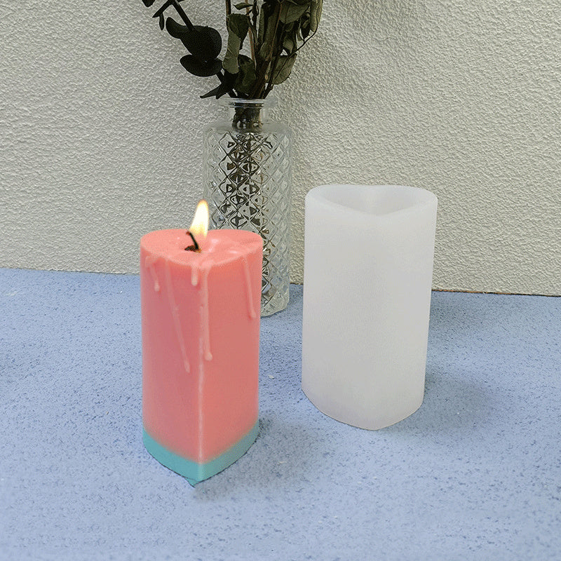 Heart cylinder silicone candle mould with pink heart-shaped candle and white mould on table.