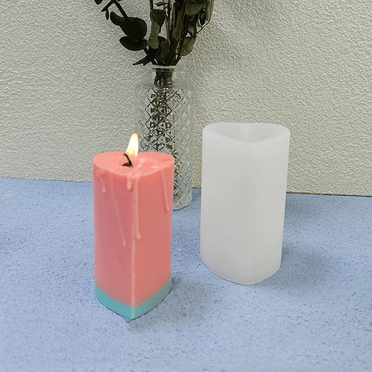 Heart cylinder silicone candle mould with pink heart-shaped candle and white mould on table.