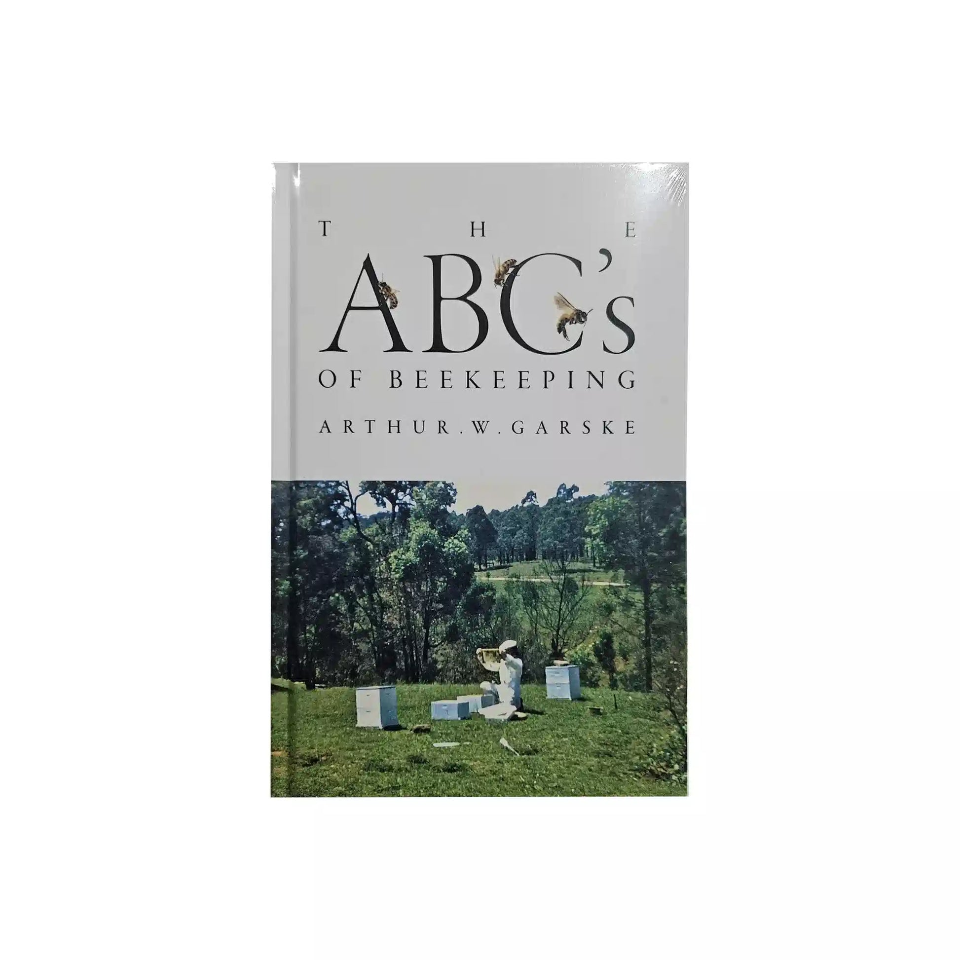Book cover of 'The ABC's of Beekeeping' by Arthur W. Garske with a beekeeper and beehives on a grassy field.
