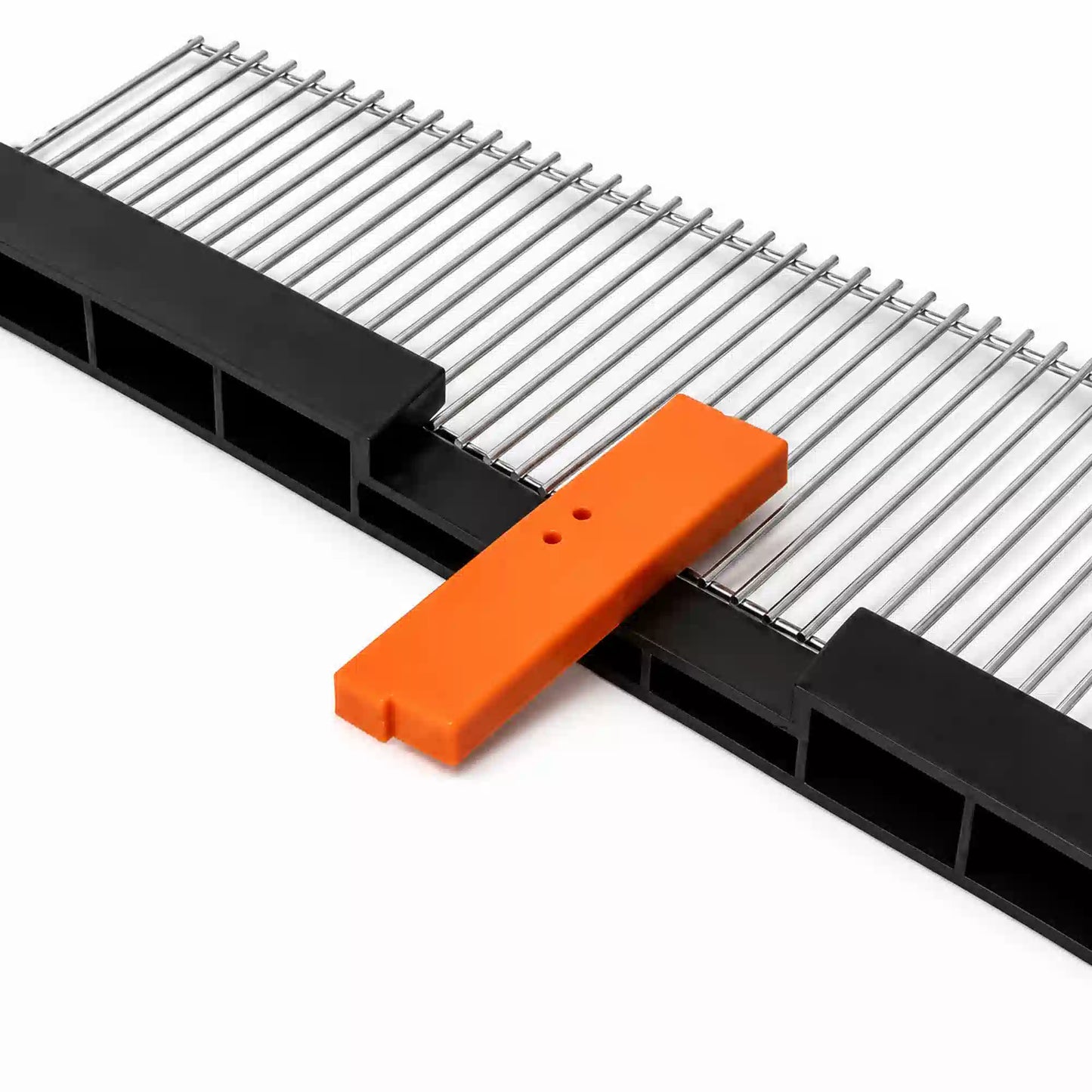Queen excluder grid with orange hive tool