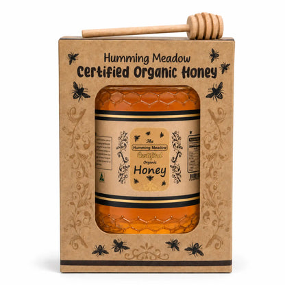 Humming Meadow organic honey gift set with a wooden honey dipper sitting on top of the kraft box