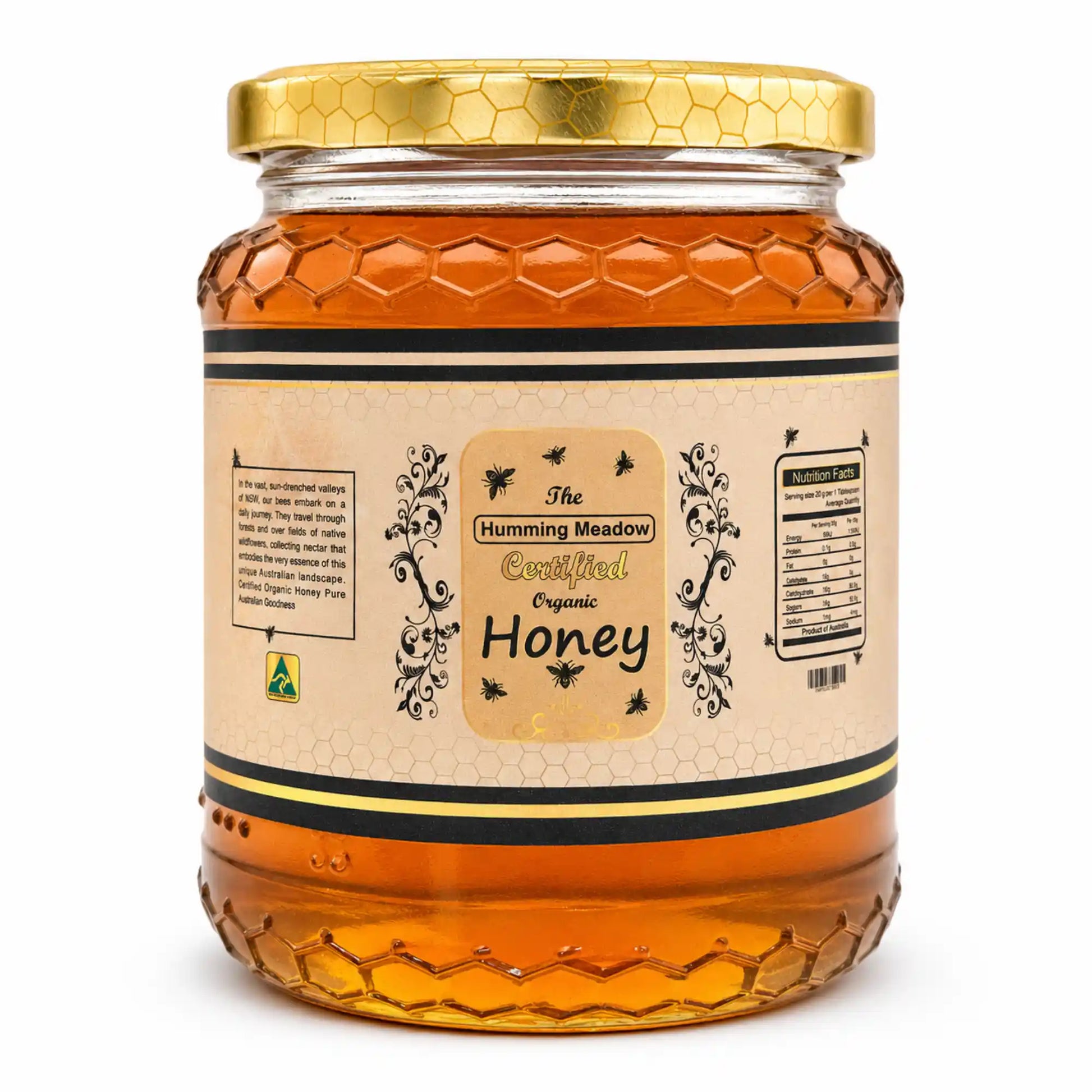 honey-glass-jar.webpGlass jar of Humming Meadow raw organic honey with honeycomb-textured base and gold lid on a white background