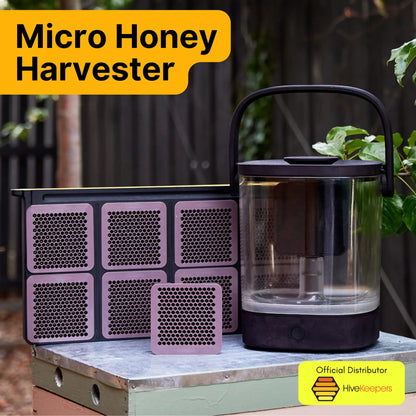 Micro Honey Harvester displayed outdoors on a hive box alongside six honeycomb cassettes