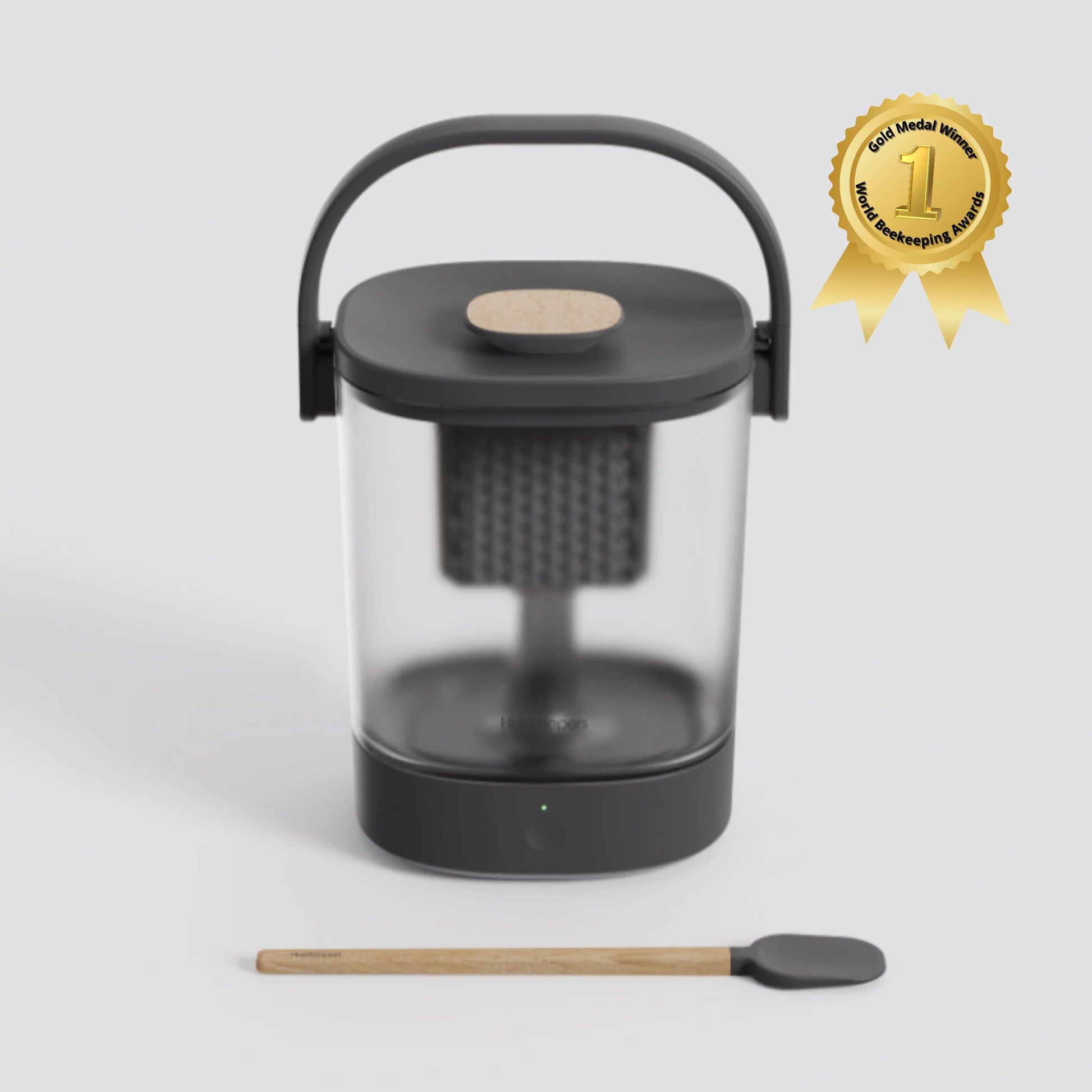 Micro Honey Harvester with clear honey collection bowl and wooden stirring spoon, gold medal winner badge