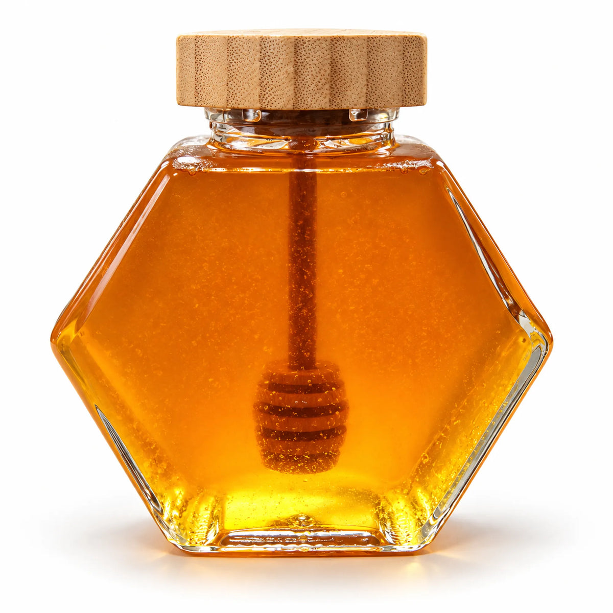 Hexagon glass jar of 300g raw organic Bloodwood honey with a bamboo lid and wooden honey dipper on a white background