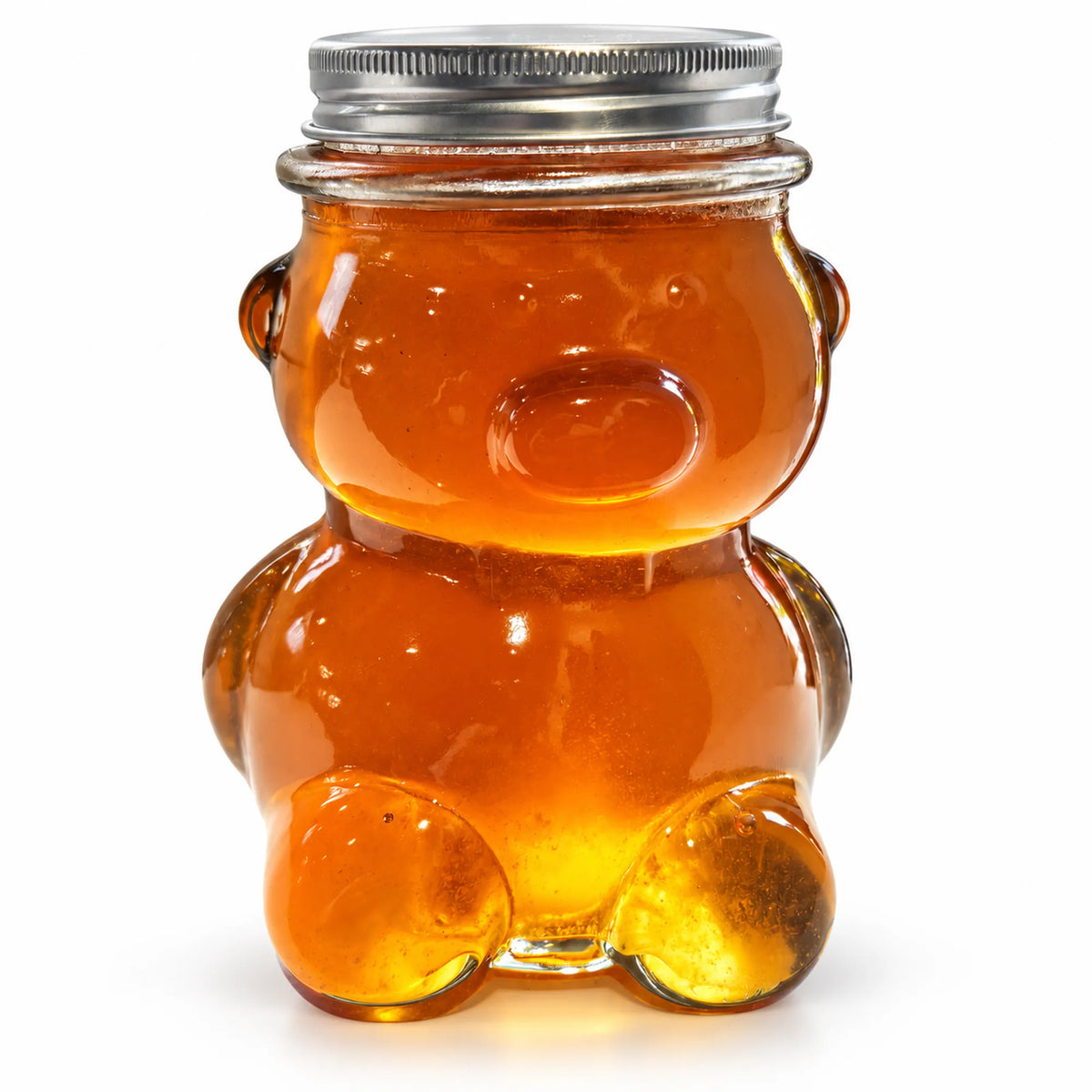 Glass teddy bear jar filled with 450g of raw organic Bloodwood honey with a silver screw lid on a white background