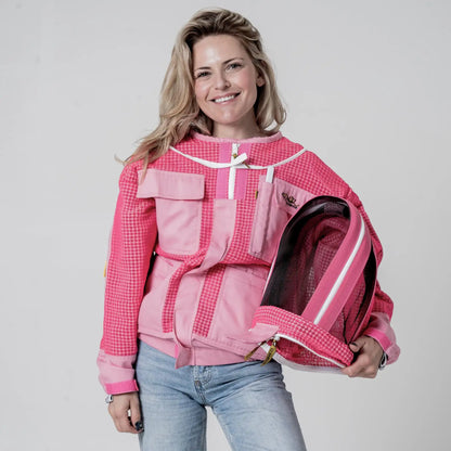 Woman wearing OZ Armour pink 3 layer beekeeping jacket holding the detached fencing veil hood under her arm, front view
