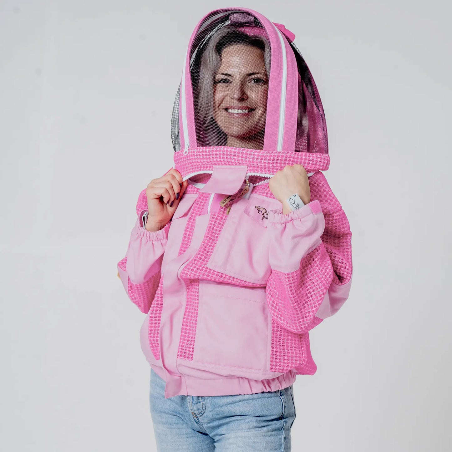 Woman wearing OZ ARMOUR pink beekeeping jacket with fencing veil hood up, front view
