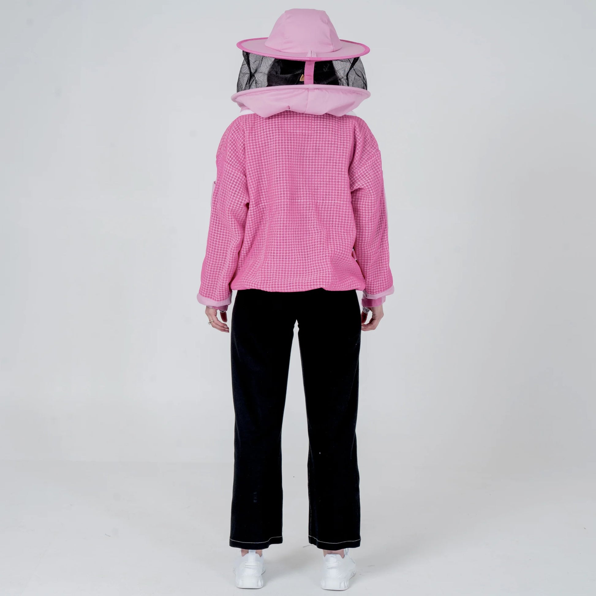 Woman wearing OZ ARMOUR pink beekeeping jacket with round veil hat, back view full body