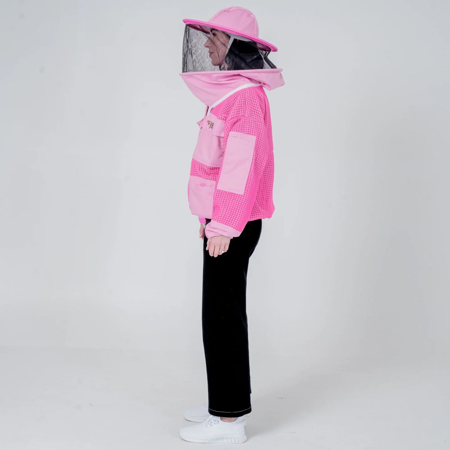 Woman wearing OZ ARMOUR pink beekeeping jacket with round veil hat, side view full body