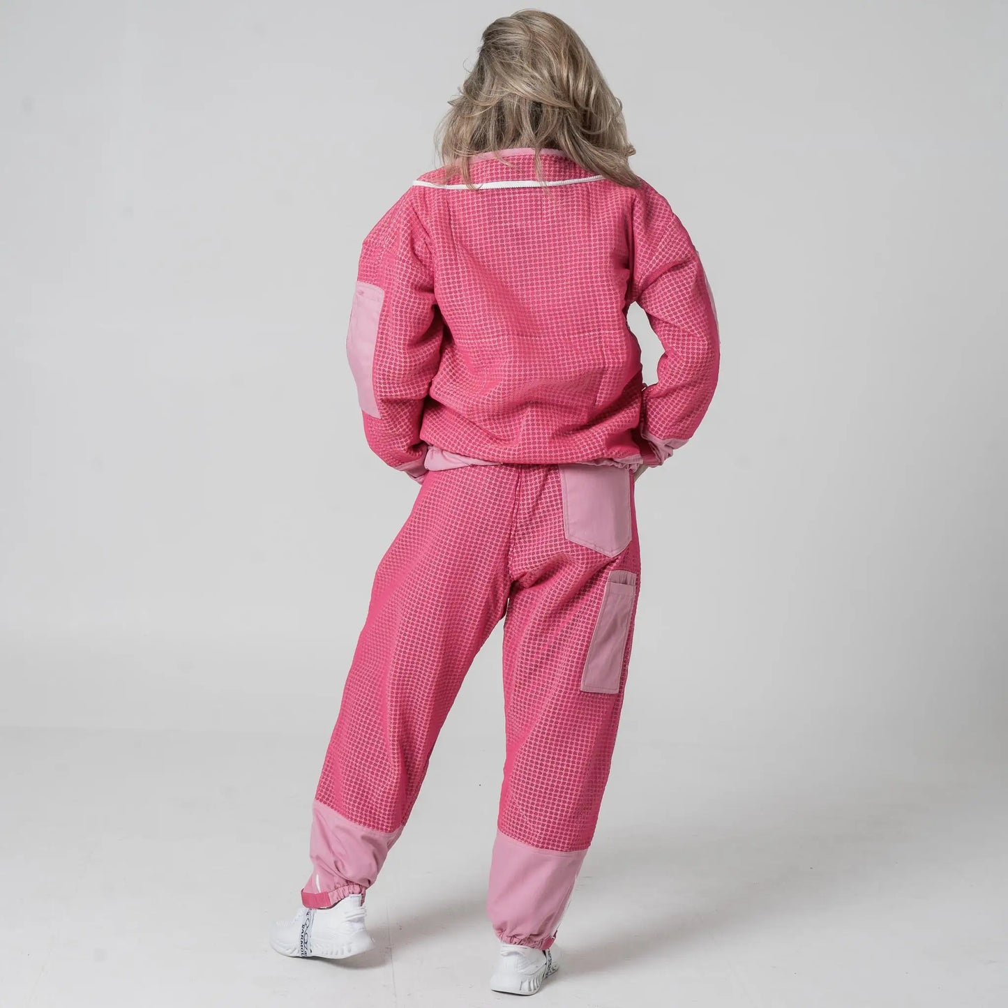 Woman wearing OZ Armour pink beekeeping jacket and trouser set, back view
