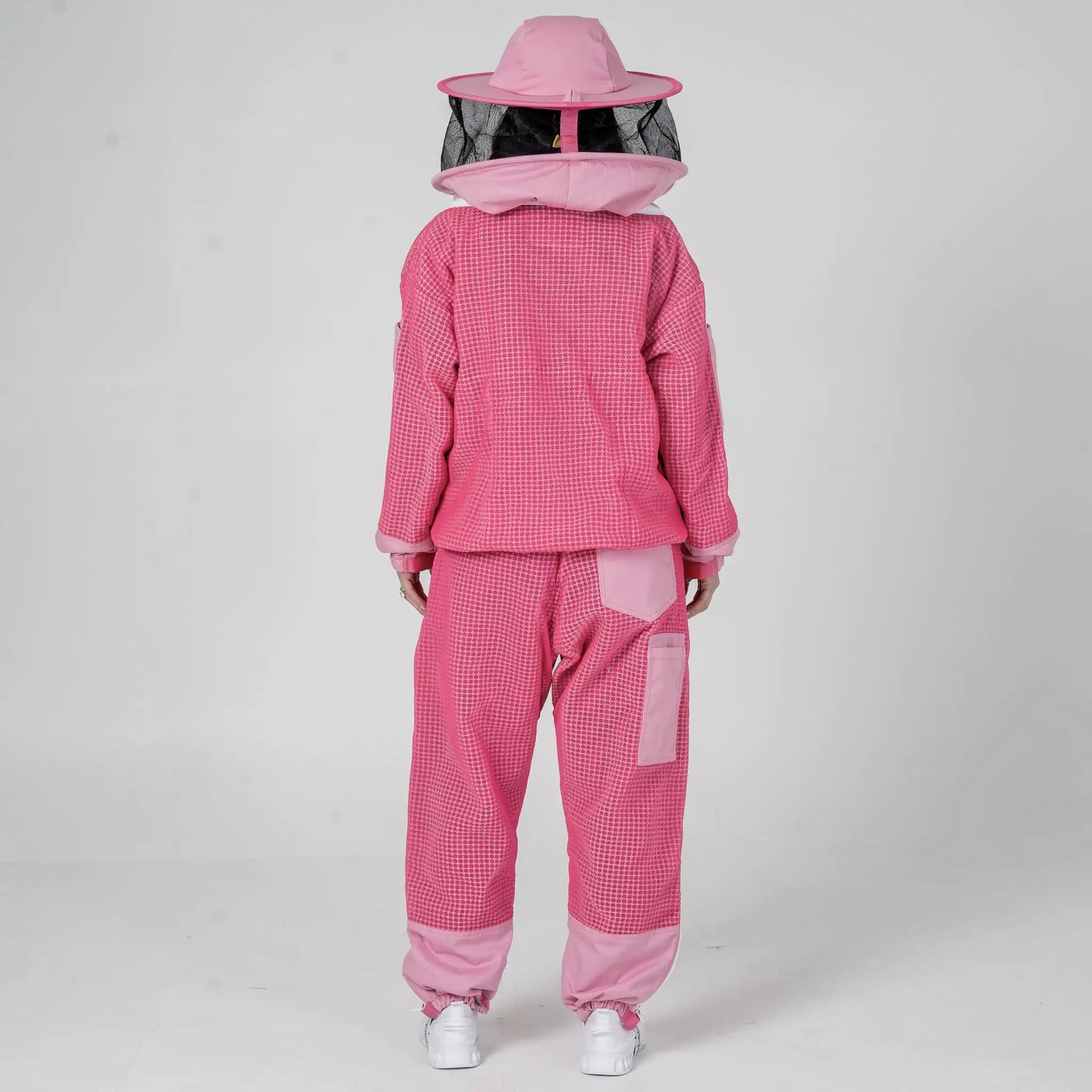  Woman wearing OZ Armour pink beekeeping jacket and trouser set with round hat veil hood up, back view
