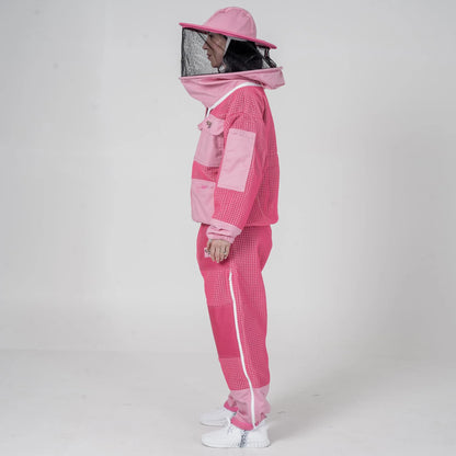 Woman wearing OZ Armour pink beekeeping jacket and trouser set with round hat veil hood up, side view
