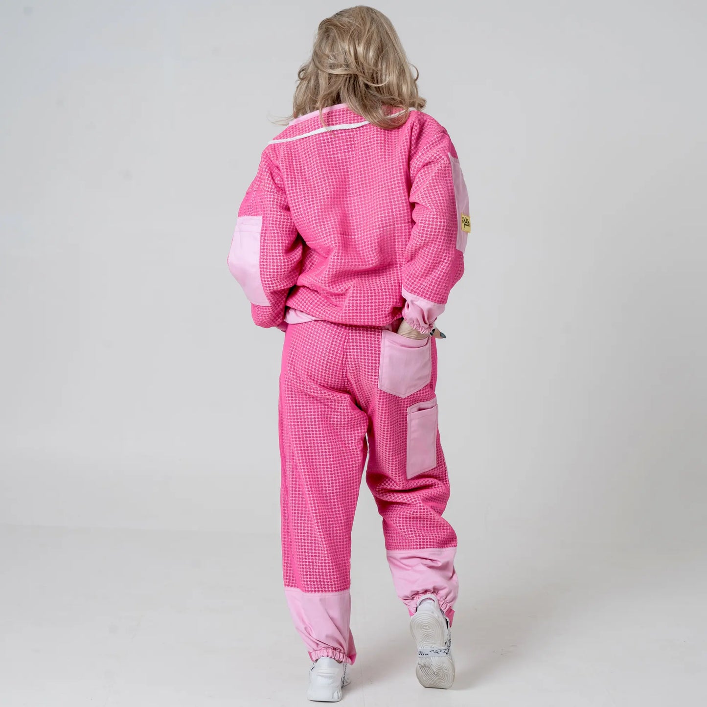 Back view of woman walking in OZ ARMOUR pink beekeeping jacket and trousers set 