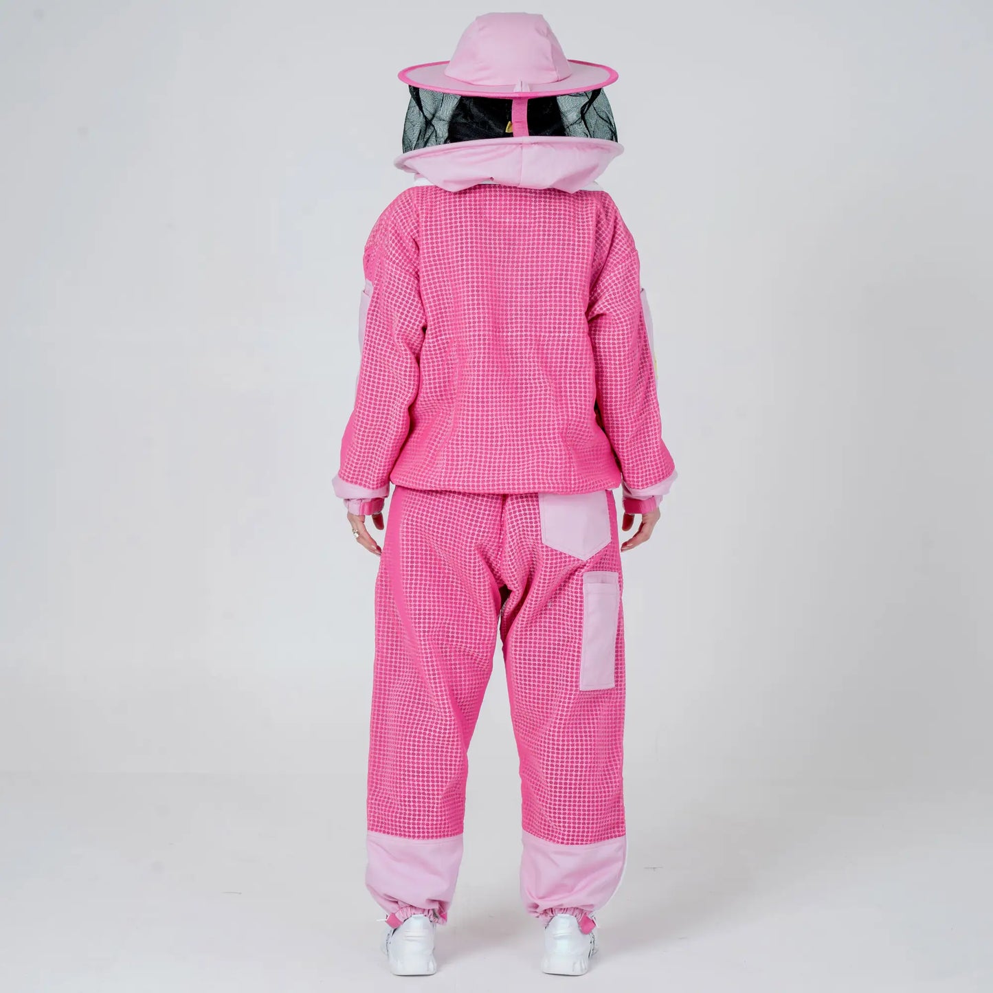 Back view of woman wearing OZ ARMOUR pink beekeeping jacket and trousers set with round veil hat