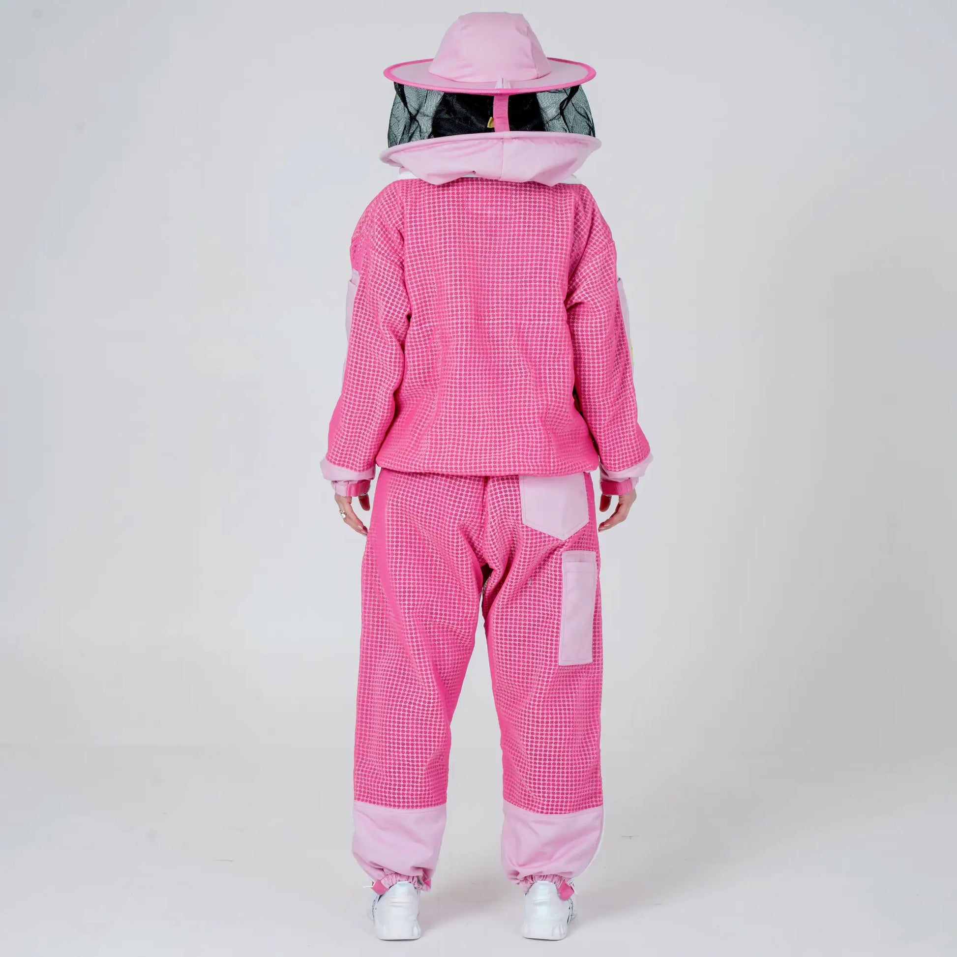 Back view of woman wearing OZ ARMOUR pink beekeeping jacket and trousers set with round veil hat