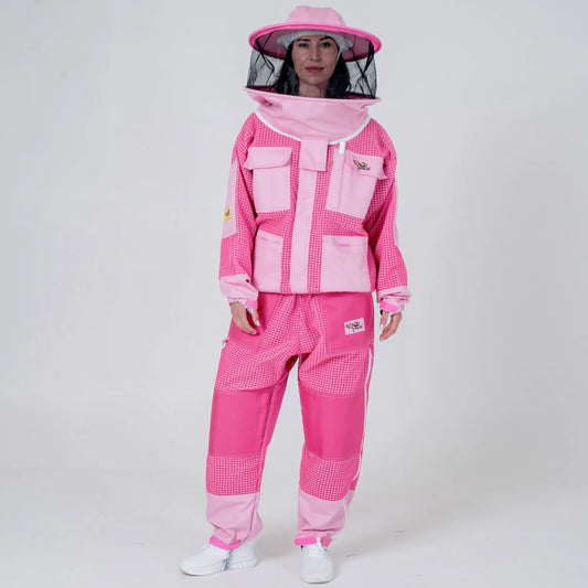 Woman wearing OZ ARMOUR pink beekeeping jacket and trousers set with round veil hood down, front view