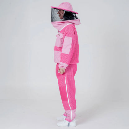 Woman wearing OZ ARMOUR pink beekeeping jacket and trousers set with round veil hat, side view