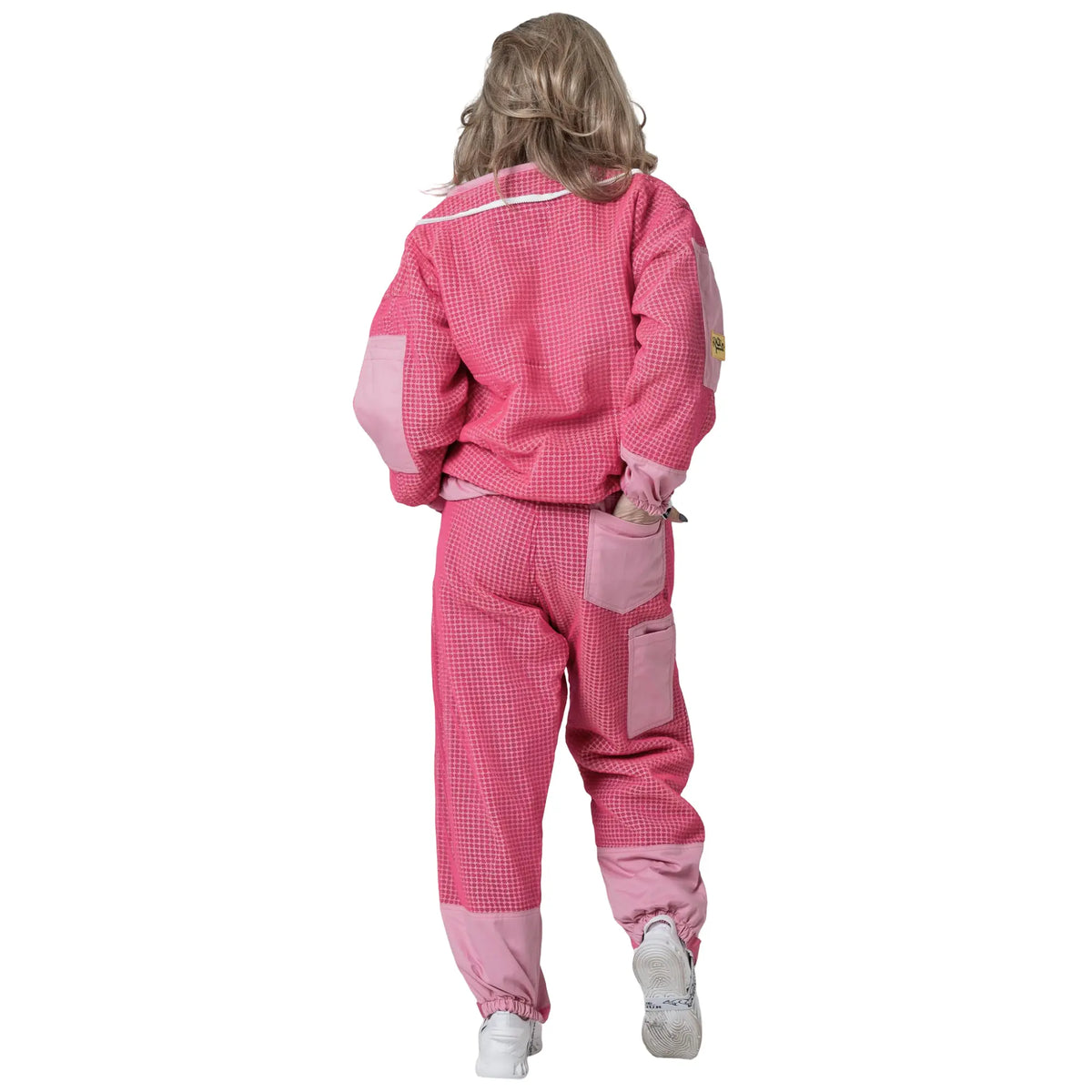 Woman walking in the OZ ARMOUR pink jacket and trousers set, back view