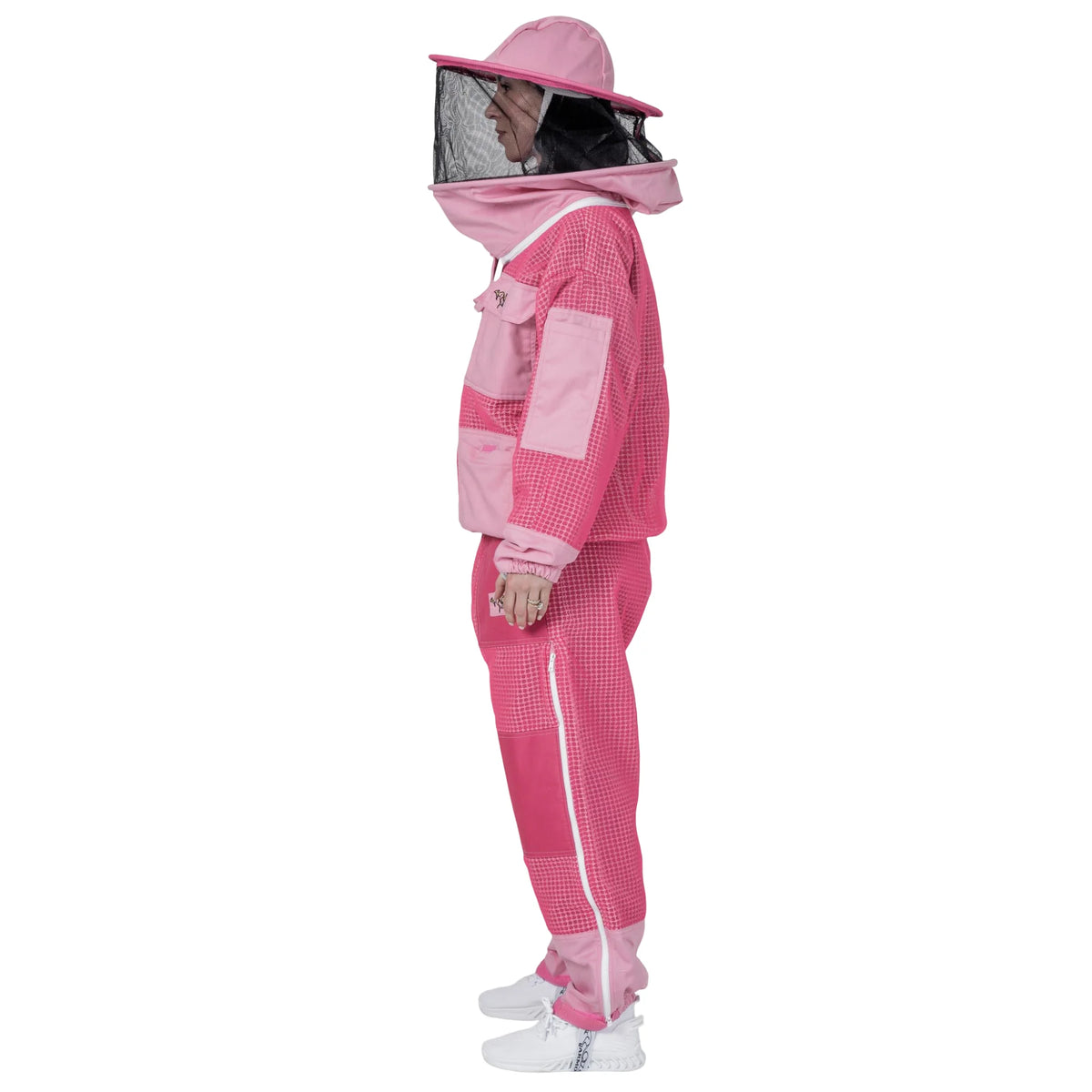 Woman wearing OZ ARMOUR pink jacket and trousers set with round hat veil, side view