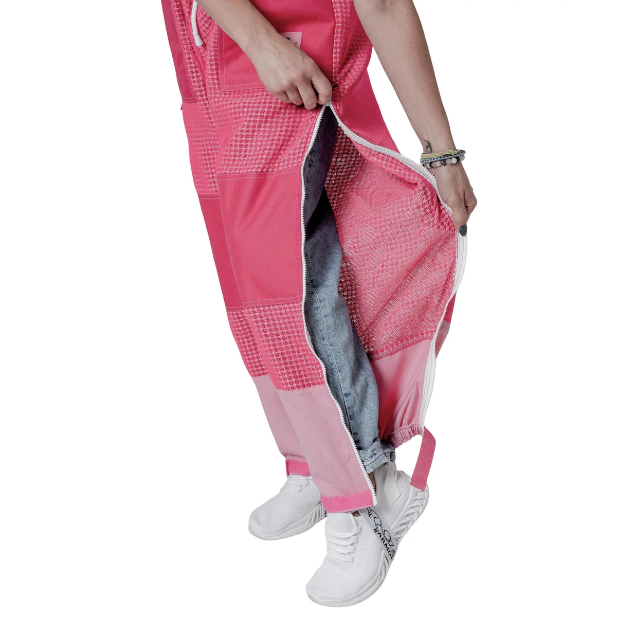Close up of leg vent zipper open showing jeans underneath on the pink beekeeping trousers