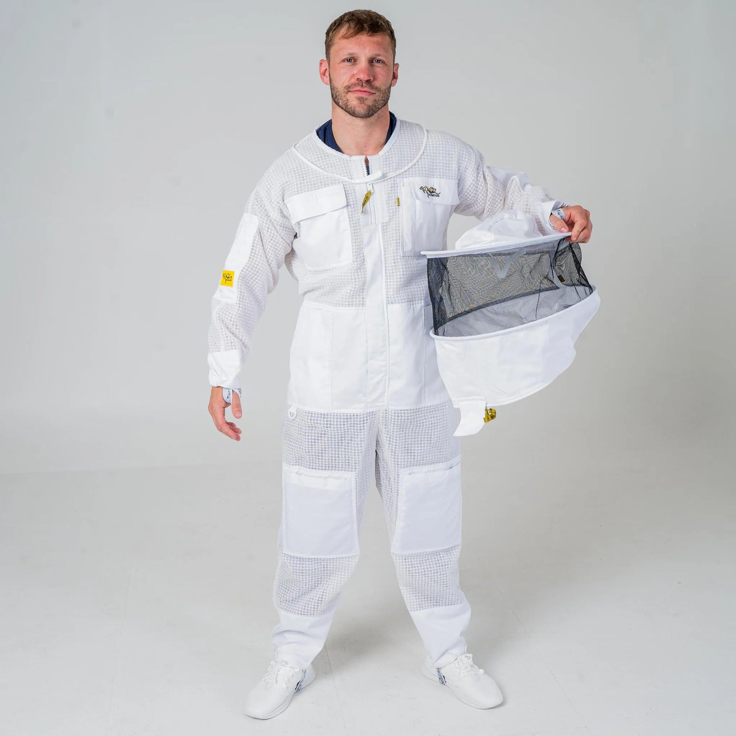 Man wearing OZ Armour white 3 layer beekeeping suit holding the detachable round hat veil, full length front view