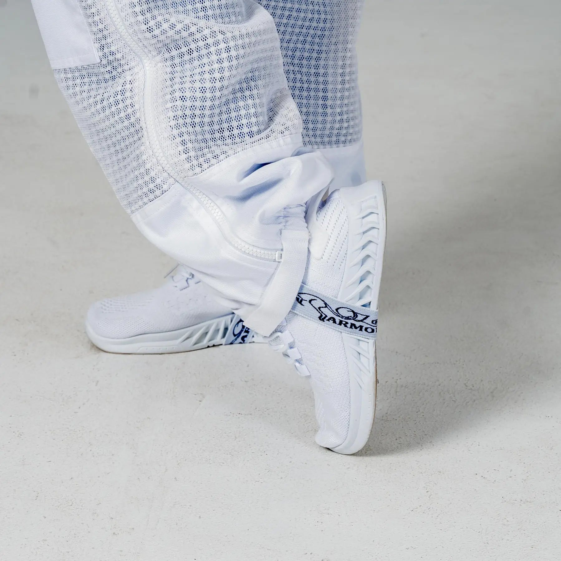 Close up of the elasticated ankle cuff over a boot on the OZ Armour white 3 layer beekeeping suit