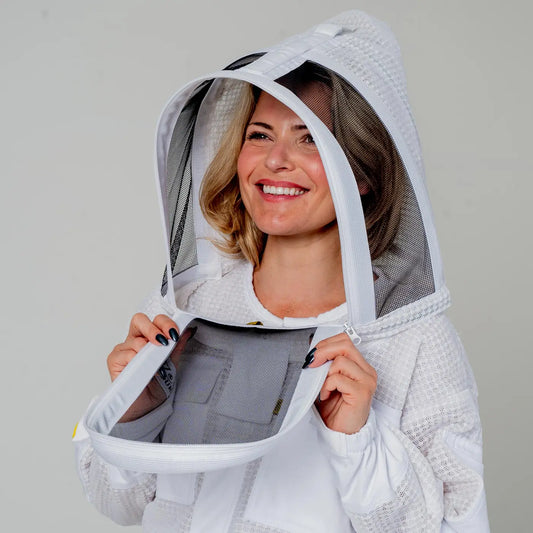 Woman wearing OZ Armour white 3 layer beekeeping suit with fencing veil hood up, close up front view