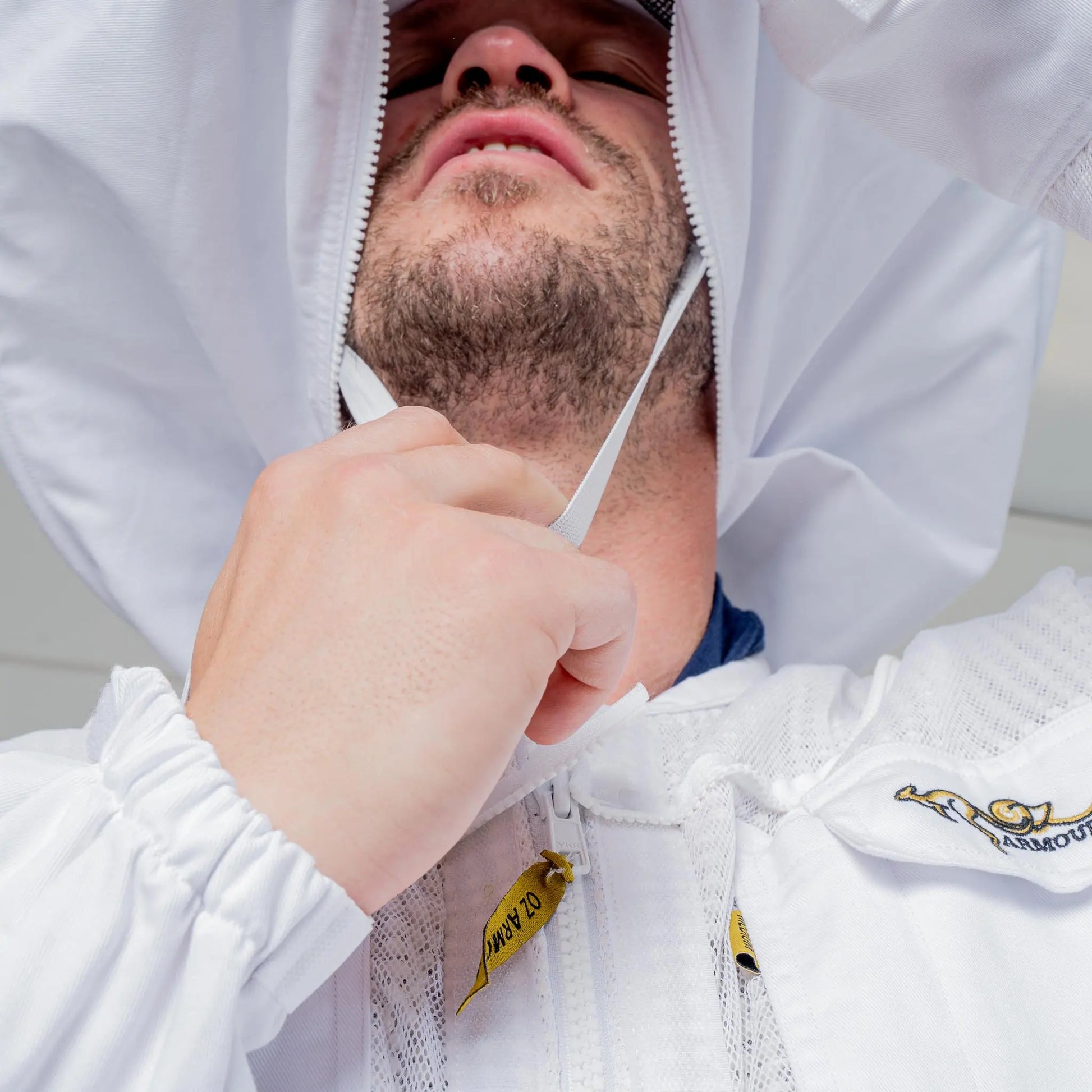 Close up of the round hat veil drawstring being tightened on the OZ Armour white 3 layer beekeeping suit