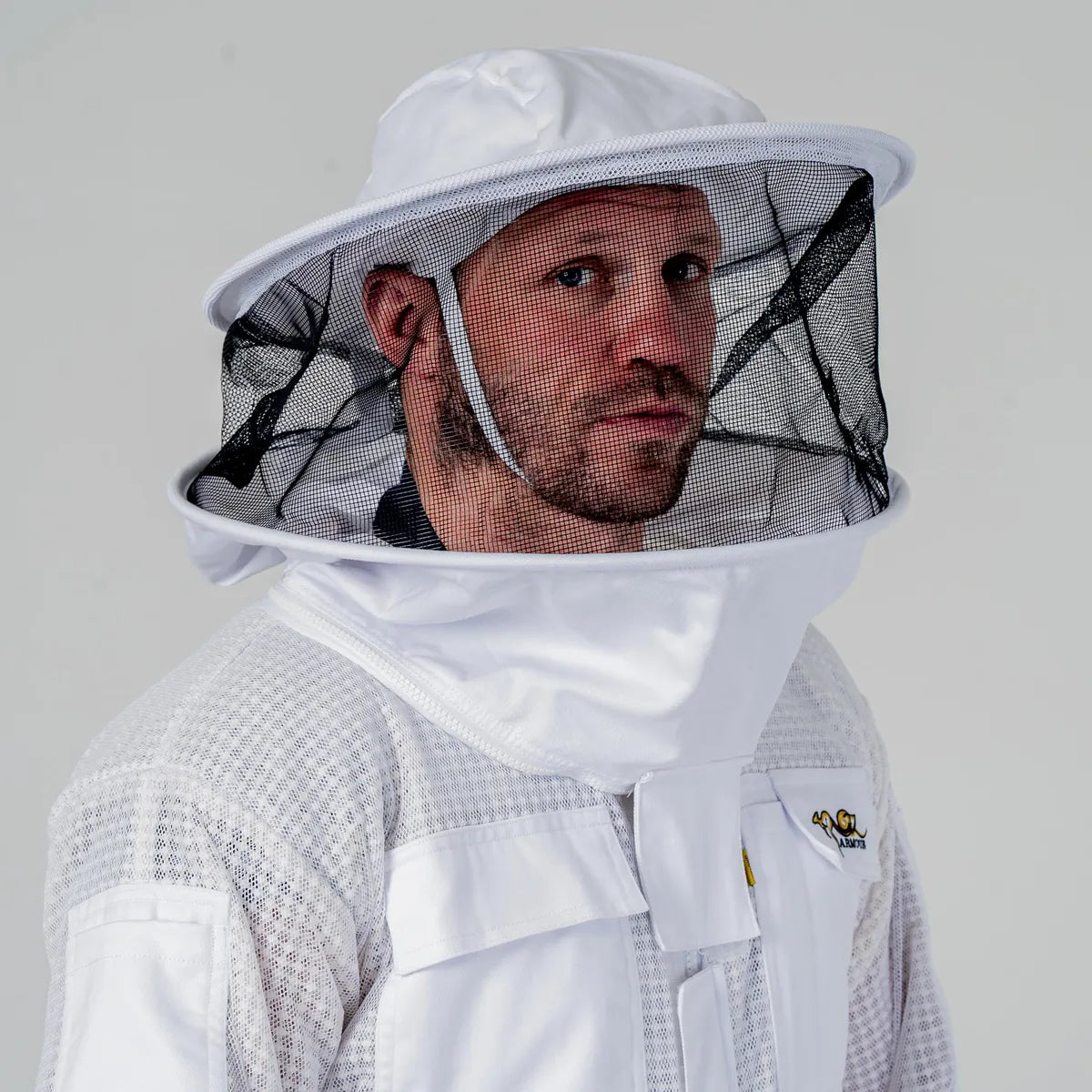 Man wearing OZ Armour white 3 layer beekeeping suit with round hat veil, close up front view