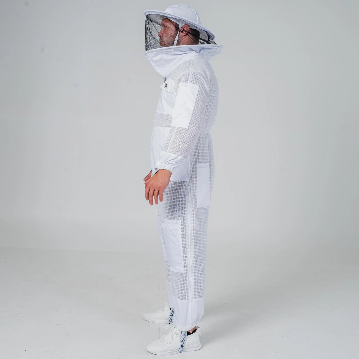 Man wearing OZ Armour white 3 layer beekeeping suit with round hat veil, full length side view