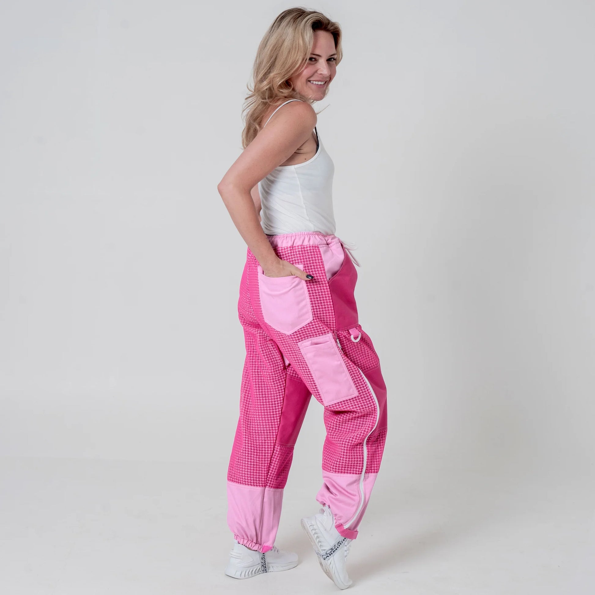 Woman wearing pink beekeeping trousers, side view full body