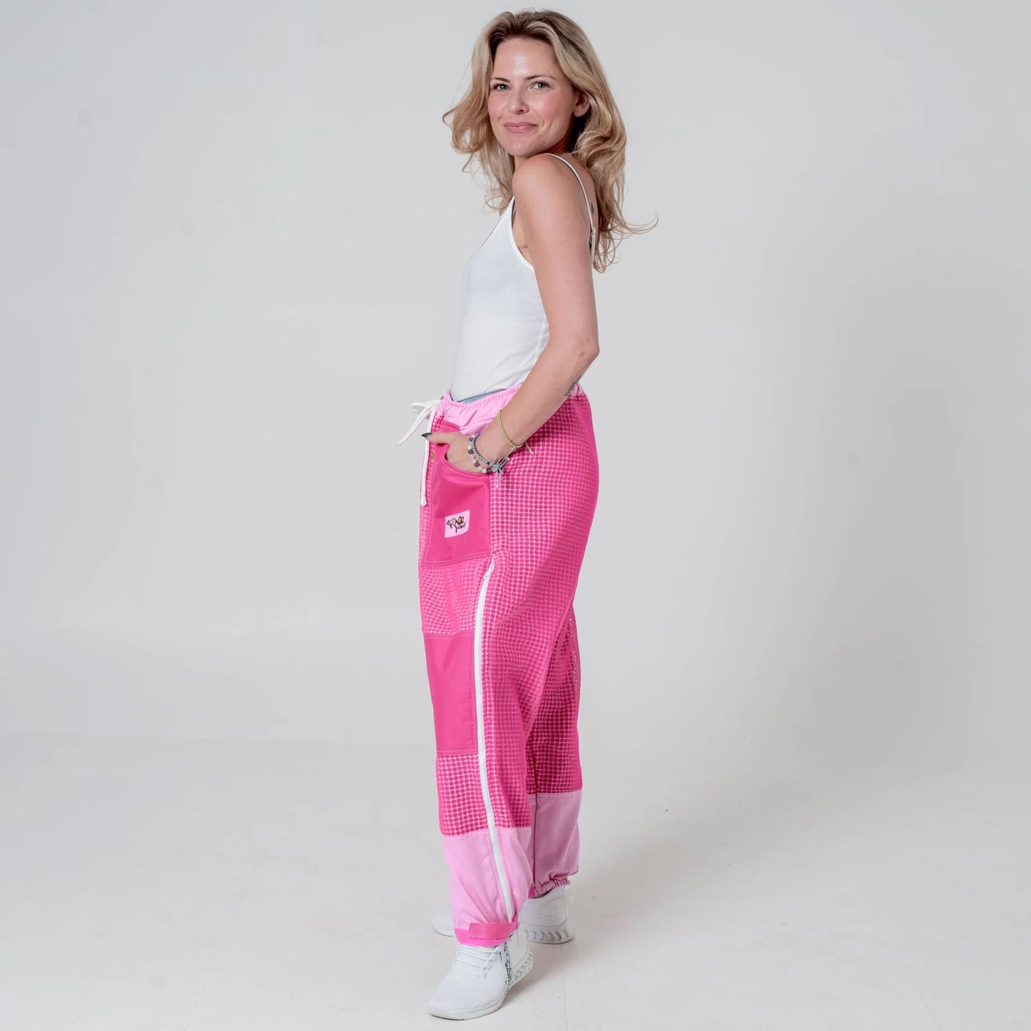 Woman wearing pink beekeeping trousers, side back view full body