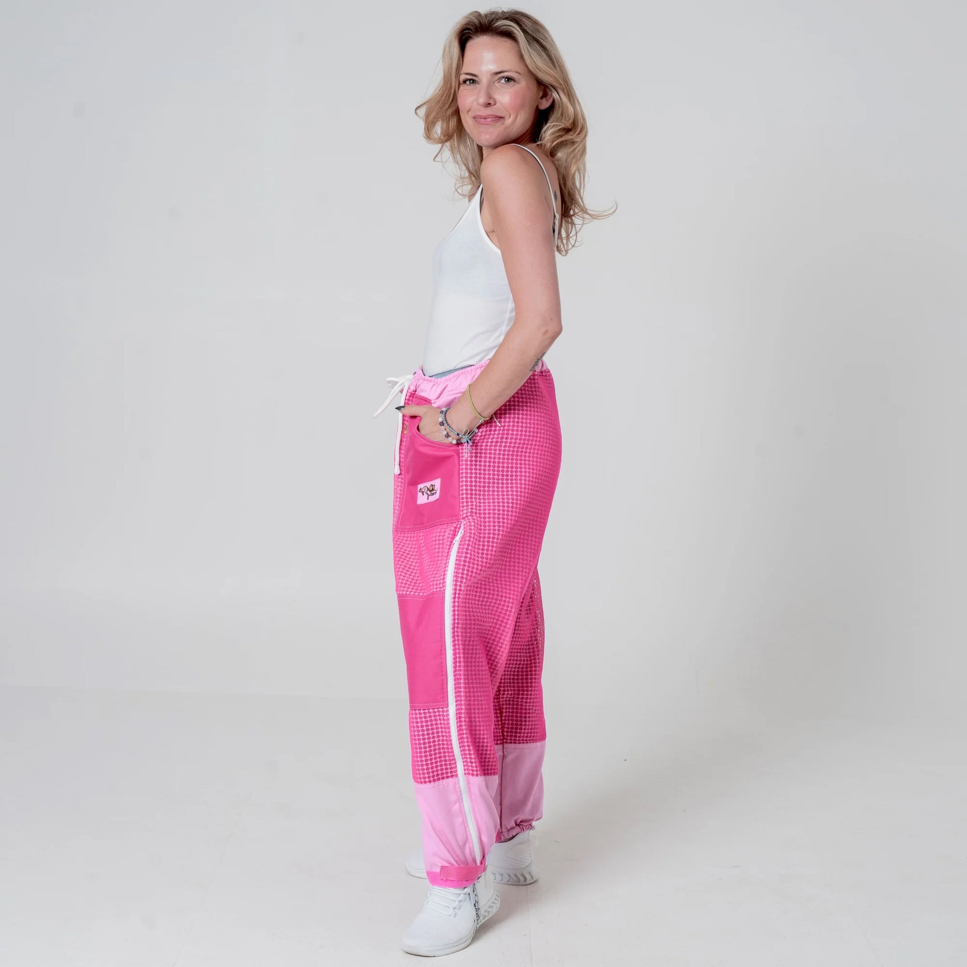 Woman wearing pink beekeeping trousers, side back view full body