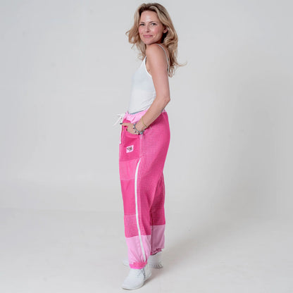 Woman wearing pink beekeeping trousers, side back view full body