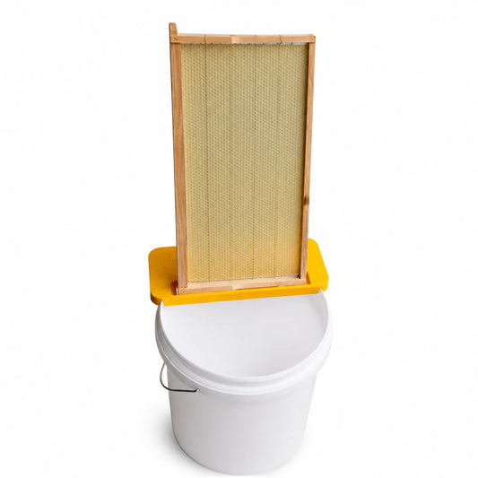 Beekeeping uncapping bench with honey frame and bucket