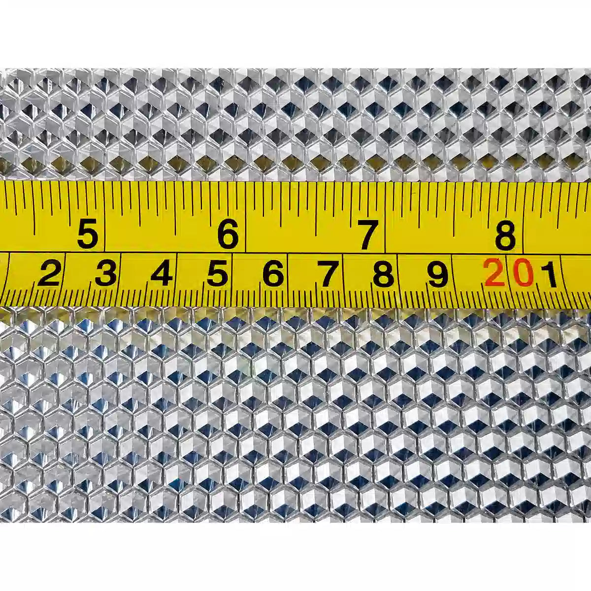 Close-up of wax foundation sheet pattern with measuring tape on machine